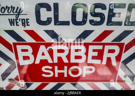 Red white navy sorry we`re closed door sign hanging on a barber shop front glass door Stock Photo